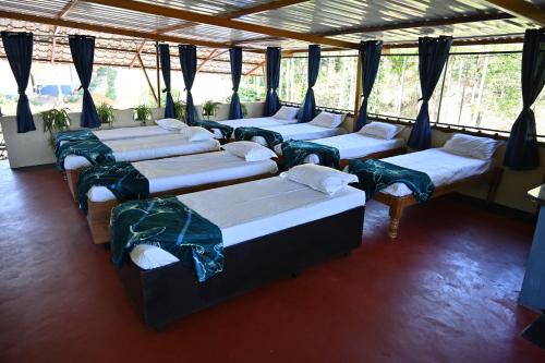 a group of four beds in a room at Alekadu hill view homestay in Mudigere