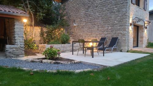 a patio with a table and chairs in a yard at 2 Gites dans les remparts à Dun sur Meuse in Dun-sur-Meuse