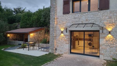 a house with a patio with a table and a kitchen at 2 Gites dans les remparts à Dun sur Meuse in Dun-sur-Meuse