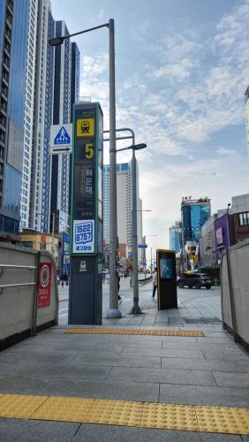 a gas station on a city street with tall buildings at JB Plus Hotel in Busan