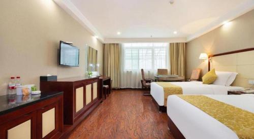 a hotel room with two beds and a television at GreenTree Inn Taiyuan PinGYAng Road Business Hotel in Taiyuan