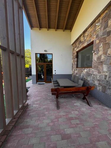 a patio with a bench and a stone wall at MátraForRest in Mátraszentistván