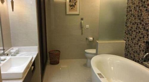 a bathroom with a tub and a toilet and a sink at Jinjiang Metropolo Shanghai Minhang in Shanghai