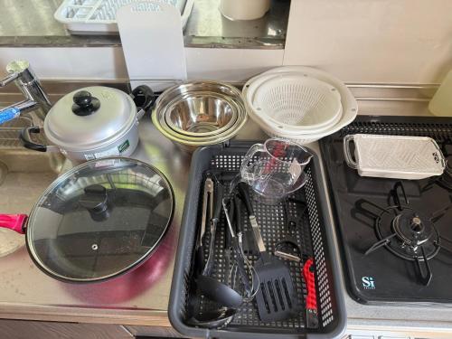 a kitchen counter with a sink with utensils in it at ＳｅａＳａｉｄｅＨｏｕｓｅ湯河原 in Yugawara