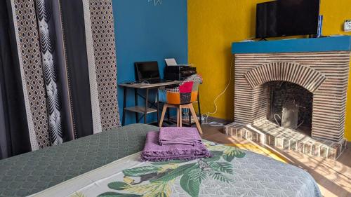 a bedroom with a bed and a fireplace at La cité des abeilles in Villemandeur