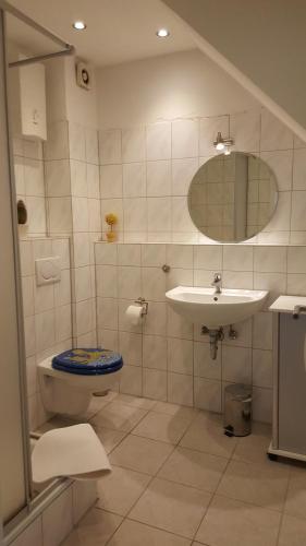 un bagno con lavandino, WC e specchio di Tuvalu a Remagen