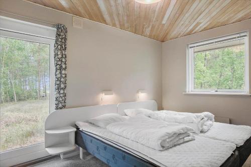 ein weißes Bett in einem Zimmer mit Fenster in der Unterkunft 1584 Aakirkeby - Poseregårdsvejen 16 in Vester Sømarken