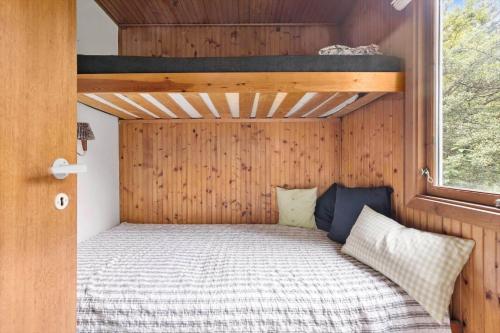 a bedroom with a bed in a wooden wall at 2700-Nexo-Munkegardsskoven-3 in Neksø