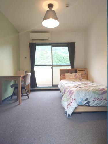 a bedroom with a bed and a desk and a window at Cate no mori - Vacation STAY 20958v in Shime