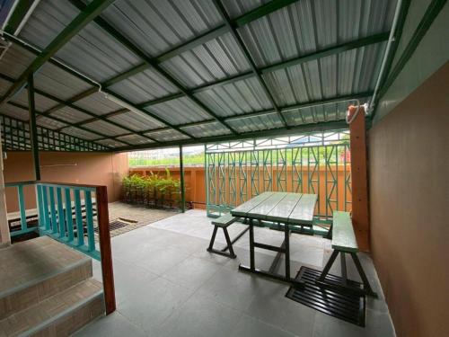 a screened in porch with a table and a bench at Hihotel Saraburi in Sara Buri