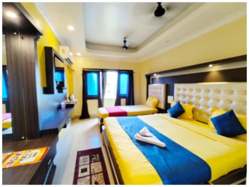 a bedroom with two beds with blue and yellow at SEA VIEW from ROOFTOP And BALCONY- Beachfront Hotel - PRIVATE BEACH AREA- GARDEN - HOTEL Retreat Asish Puri in Puri