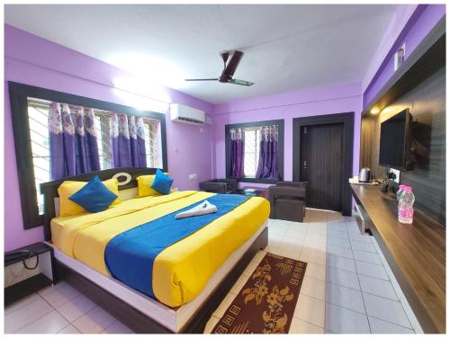 a bedroom with a large bed with yellow and blue sheets at SEA VIEW from ROOFTOP And BALCONY- Beachfront Hotel - PRIVATE BEACH AREA- GARDEN - HOTEL Retreat Asish Puri in Puri