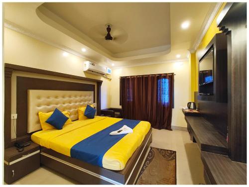 a bedroom with a large bed with yellow and blue pillows at SEA VIEW from ROOFTOP And BALCONY- Beachfront Hotel - PRIVATE BEACH AREA- GARDEN - HOTEL Retreat Asish Puri in Puri