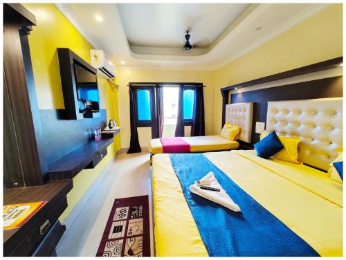 a hotel room with two beds and a television at SEA VIEW from ROOFTOP And BALCONY- Beachfront Hotel - PRIVATE BEACH AREA- GARDEN - HOTEL Retreat Asish Puri in Puri