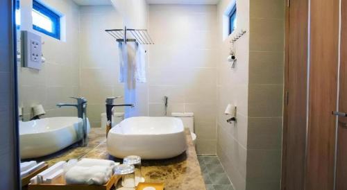 a bathroom with a large tub and a sink at Gold View Boutique Hotel Đà Lạt in Da Lat