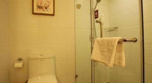 a bathroom with a toilet and a glass shower at Yitel Collection Lianyungang High-speed Railway Station Suning Plaza in Lianyungang