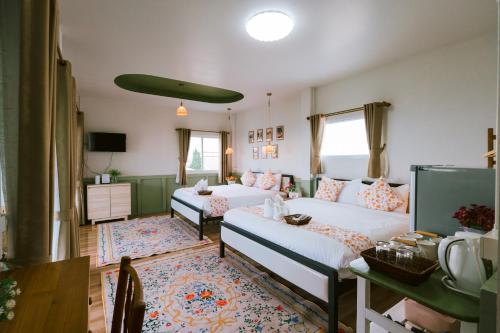 a living room with two beds and a tv at SUNYA Doichang in Ban Huai Khai