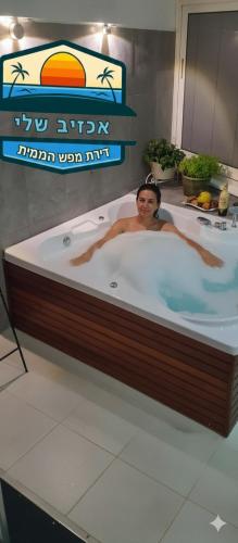 a woman is in a bathtub in a restaurant at דירת נופש באכזיב עם ג'קוזי מול חוף בננה ביץ Dream Place Achziv in Nahariyya