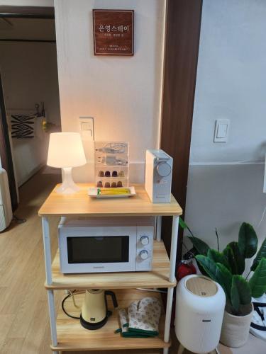 a microwave on a table with a lamp on it at Eunyoung Stay in Suwon