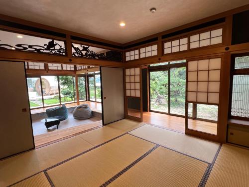 a japanese room with glass doors and a living room at 甚兵衛邸 in Hirado