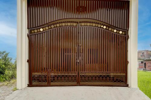 a large wooden door with a gate in a field at SPOT ON The Soraon Residency in Phāphāmau