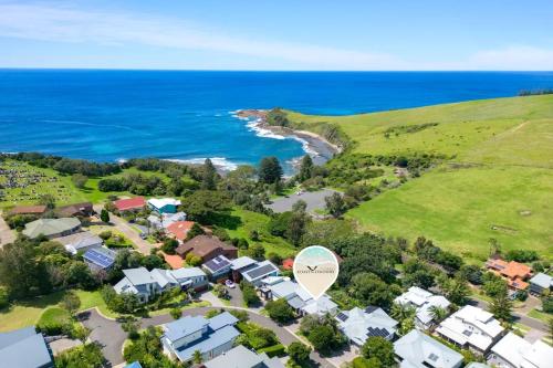 an aerial view of a suburb with houses and the ocean at Cookes Haven in Gerringong