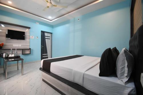 a bedroom with a bed with a blue wall at Hotel O Prince Residency in Bhubaneshwar