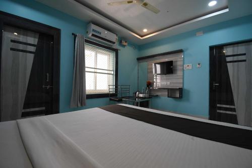 a bedroom with a large bed with blue walls at Hotel O Prince Residency in Bhubaneshwar