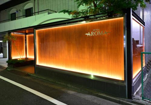 un bâtiment avec un mur orange sur le côté d'une rue dans l'établissement AROMA+ (Adult Only), à Tokyo