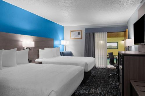 a hotel room with two beds and a television at Baymont by Wyndham Duluth Spirit Mountain in Duluth