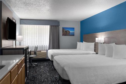 a hotel room with two beds and a television at Baymont by Wyndham Duluth Spirit Mountain in Duluth