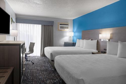a hotel room with two beds and a flat screen tv at Baymont by Wyndham Duluth Spirit Mountain in Duluth