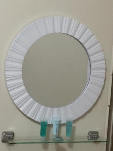 a large mirror on a wall with two glasses on a shelf at The Nosh & Nod - Avon Terrace in York