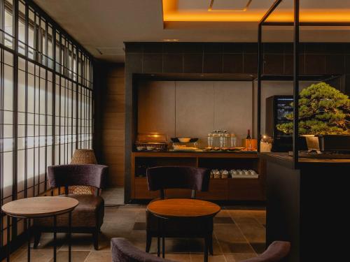 a restaurant with two tables and chairs and a counter at Hotel Gracery Kyoto Sanjo in Kyoto