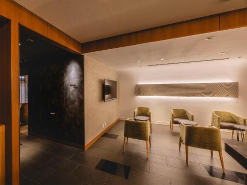 a waiting room with chairs and tables and a wall at Hotel Gracery Kyoto Sanjo in Kyoto