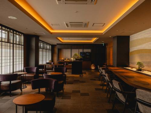 a restaurant with tables and chairs and a bar at Hotel Gracery Kyoto Sanjo in Kyoto