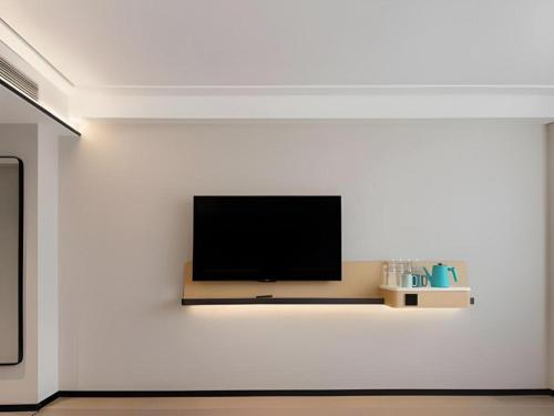 a flat screen tv on a white wall at City Comfort Inn Wuhan Hankou Railway Station West Square in Wuhan