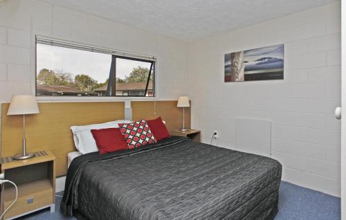 a bedroom with a bed and a window at Walton Park Motor Lodge in Warkworth