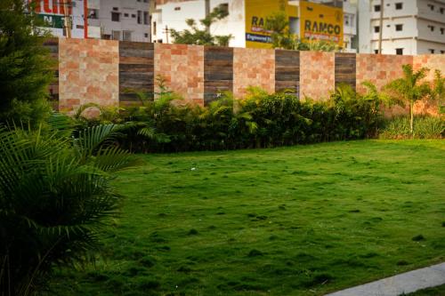 a yard with green grass in front of a building at Hotel O A R International in Shamshabad