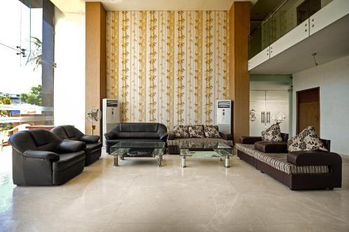 a lobby with couches and chairs and a table at Hotel O A R International in Shamshabad