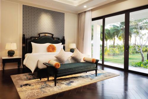 a bedroom with a bed and a green couch at Wyndham Grand Phu Quoc in Phu Quoc