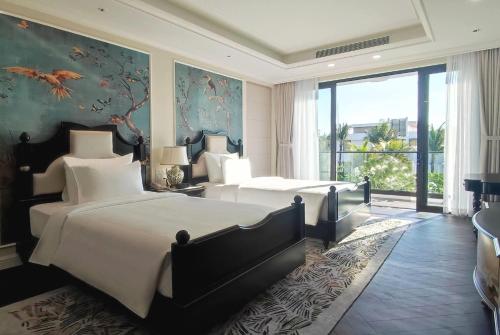 a bedroom with two beds and a large window at Wyndham Grand Phu Quoc in Phu Quoc