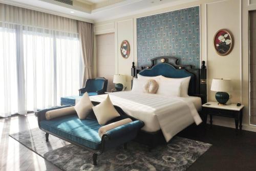 a bedroom with a large bed and a couch at Wyndham Grand Phu Quoc in Phu Quoc