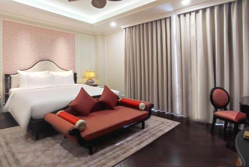 a bedroom with a bed and a red couch at Wyndham Grand Phu Quoc in Phu Quoc