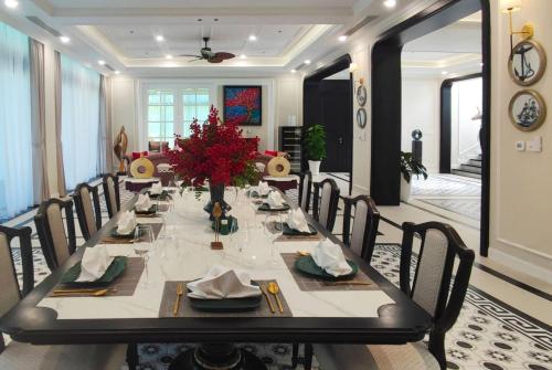a dining room table with chairs and a long table with flowers at Wyndham Grand Phu Quoc in Phu Quoc