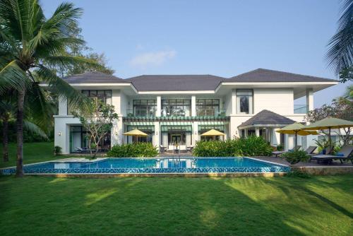 an exterior view of a house with a swimming pool at Wyndham Grand Phu Quoc in Phu Quoc