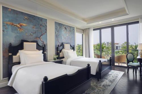 a bedroom with two beds and a wall of windows at Wyndham Grand Phu Quoc in Phu Quoc