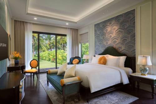 a bedroom with a large bed and a green couch at Wyndham Grand Phu Quoc in Phu Quoc