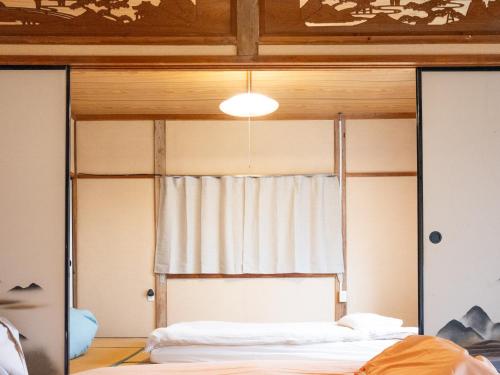 a bedroom with two beds and a window at Gracciaso in Aso