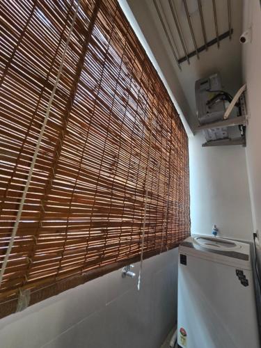 a bathroom with a large window with wooden blinds at Saptagiri elite 104 in Kondapur